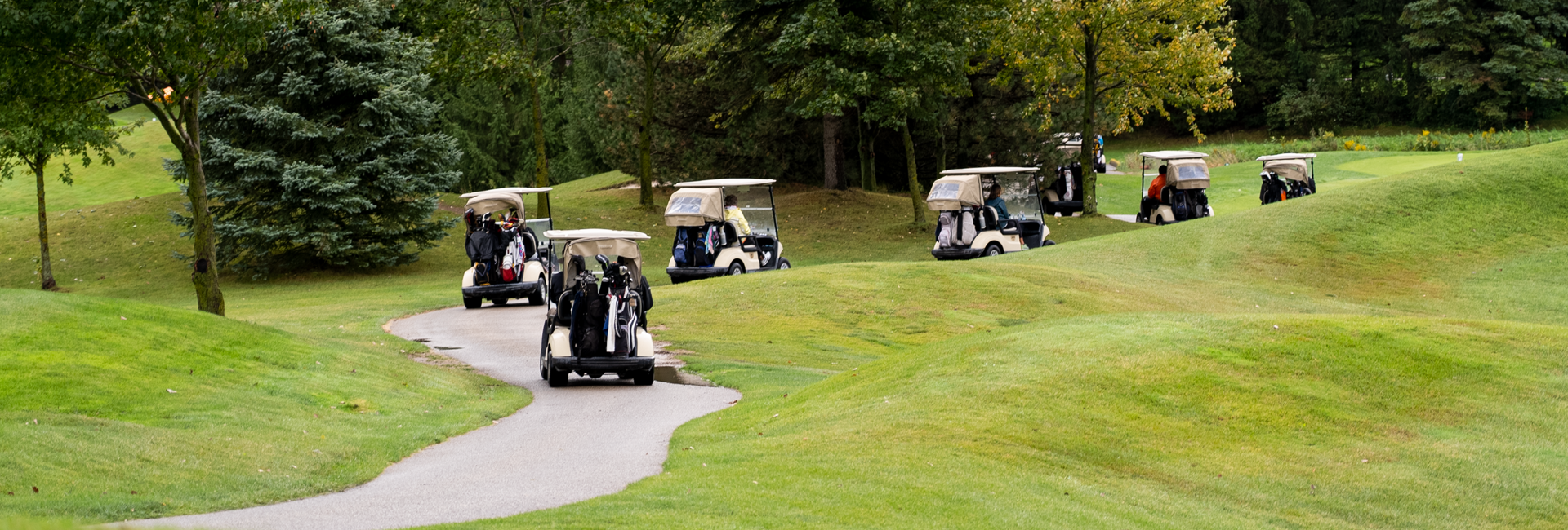 Golfers in carts on their way to their first holes.